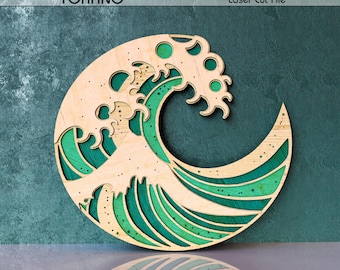 May include: A multi-layered laser cut wood wall art piece depicting a stylised ocean wave in a circular frame. The design features light wood-toned top layers with intricate cutouts revealing deep green and teal coloured layers underneath.