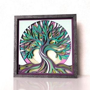 May include: A square wall art piece featuring a multi-layered, laser-cut wooden tree design inside a circular frame. The tree displays intricate branches and roots in shades of teal, purple, green, and white, set against a pale background.
