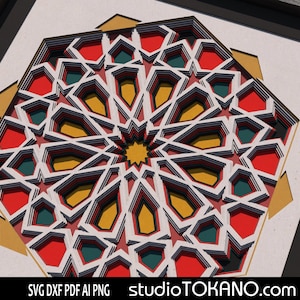 May include: A layered paper art piece featuring a geometric design with red, green, yellow, and white shapes. The artwork is framed in black and has a complex, multi-dimensional appearance. The design is symmetrical and intricate.