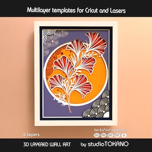 May include: A 3D layered wall art template featuring a central orange circle with a white ginkgo leaf branch design. The artwork includes purple background layers and decorative wave patterns in the corners, framed in white. Text reads Multilayer templates for Cricut and Lasers, 6 layers, for 8.5x11 cardstock, 3D LAYERED WALL ART, and studioTOKANO.