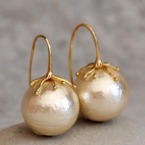 Pendientes grandes de perlas doradas: diseño llamativo con perlas de algodón.