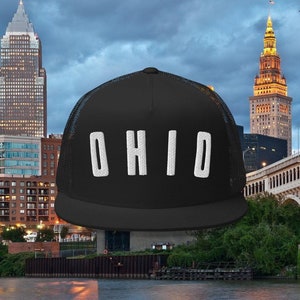 May include: Black trucker hat with a white mesh back and the word "OHIO" in white letters on the front.