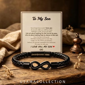 Op de afbeelding: Een zwarte gevlochten leren armband met een matzwart oneindigheidssymbool in het midden en een magnetische sluiting gegraveerd met de woorden Love you forever. Achter de armband staat een witte kaart met de tekst To My Son.