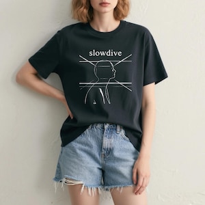 May include: Black t-shirt with the word "slowdive" above a white line drawing of a person's profile. The shirt is paired with denim shorts.
