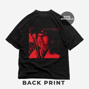 以下が含まれることがあります： 「Loveless」の「my bloody valentine」のアルバムカバーの赤いグラフィックプリントが施された黒いTシャツ。