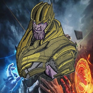 May include: Embroidered patch featuring Thanos from the Marvel comics. The patch showcases Thanos's face and upper body in shades of gold, purple, and gray. The background has a dark, dramatic color scheme with blue and orange accents.