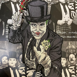 Può includere: Toppa ricamata raffigurante un personaggio con cilindro e abito, con capelli verdi e rossetto rosso. Il personaggio tiene in mano una piuma e un fiore. Lo sfondo presenta un'immagine in bianco e nero di persone con abiti simili.