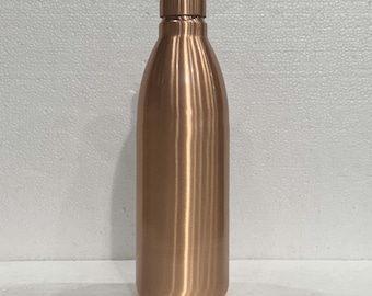 May include: A copper-colored water bottle with a rounded body and a screw-on cap. The bottle has a smooth, polished surface and a simple, elegant design. The bottle is made of metal and is designed to hold liquids.