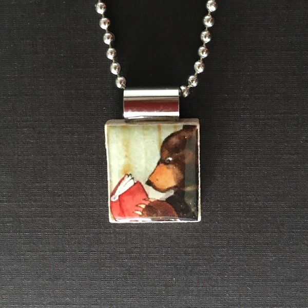 handmade jewelry featuring a bear reading a book, recycled scrabble tile pendant on a long chain, original art by Nakisha Vanderhoven