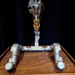 Steampunk Pipe light made from galvanised conduit in a Pipe Man robot style.