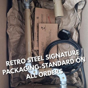 Hand-wrapped industrial lamp packaging featuring thick kraft paper, traditional rustic brown twine, and a hand-inked artisan tag. Minimalist, eco-friendly presentation for a boutique Sheffield-made 11th steel anniversary gift.