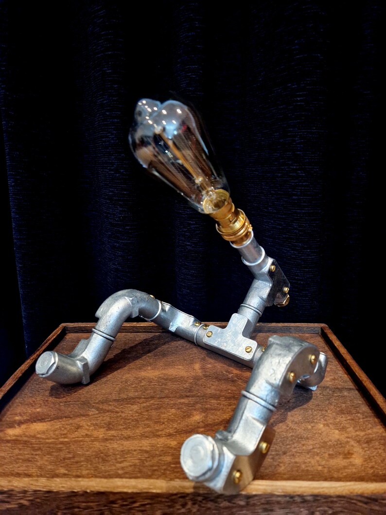 Steampunk Pipe light made from galvanised conduit in a Pipe Man robot sClose-up of a vintage LED filament bulb in a silver steel pipe fixture handcrafted in Sheffield.