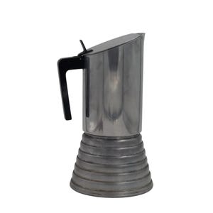 May include: A stainless steel stovetop espresso maker with a black handle and lid. The base has a ribbed design. The coffee pot is designed to brew espresso on a stovetop.