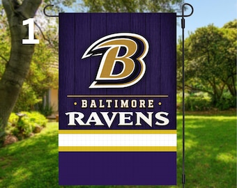 May include: A Baltimore Ravens garden flag. The flag features the team's logo, a stylized letter "B" in gold and white, set against a dark purple wooden background. The words "BALTIMORE RAVENS" are displayed in white. A yellow and white stripe is at the bottom.