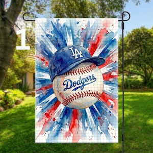 Könnte beinhalten: Eine Gartenflagge mit einem Baseball und einer blauen Dodgers-Kappe. Der Baseball hat rote Nähte und das Wort "Dodgers" in blauer Schrift. Der Hintergrund hat ein Aquarelldesign in Rot und Blau.