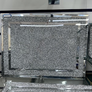 Könnte beinhalten: Ein silberner Spiegelrahmen mit einem diamantartigen Glitzer-Finish. Der Rahmen hat einen doppelten Rand und ist perfekt zum Anzeigen von Fotos oder Kunstwerken.