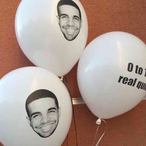 May include: Three white balloons with black printed designs. One balloon has a black and white portrait of a man. Another balloon has the text "0 to 100 real quick".