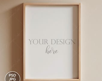 May include: A light wood frame with a white mat and the text "YOUR DESIGN here" in the center. The frame is hanging on a light beige wall.