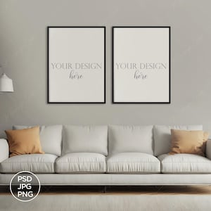 Puede incluir: Dos impresiones enmarcadas con marcos negros cuelgan sobre un sofá blanco con cojines naranjas. Las impresiones tienen el texto "YOUR DESIGN here". Una lámpara de pie y una mesa auxiliar completan la escena.