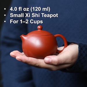 Könnte beinhalten: Ein Set aus drei Keramikbechern mit gesprenkelter, matter Oberfläche. Die Becher sind in den Farbtönen Creme, Hellgrau und Dunkelgrau gehalten. Jeder Becher hat ein schlichtes, minimalistisches Design und einen abgerundeten Henkel.