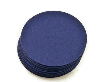 May include: A stack of circular navy blue paper cutouts. Each piece is a flat, solid-colored disc with smooth, clean-cut edges. The stack consists of multiple identical layers of dark blue cardstock, creating a uniform and simple circular shape.