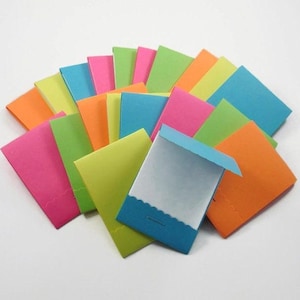 May include: A set of colorful folded paper envelopes with scalloped edges. The envelopes are in various shades of green, blue, pink, orange, and yellow.