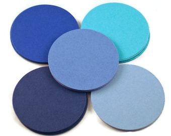 May include: Five round paper circles in shades of blue and turquoise. The circles are arranged in a semi-circle pattern.