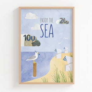 May include: Framed art print depicting a seaside scene. The artwork shows a seagull on a wooden post, the words "Enjoy the Sea", and illustrations of clouds, beach huts, and currency. The color scheme includes blue, yellow, and white.