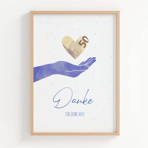 Op de afbeelding: Een ingelijste print met een blauwe aquarelhand die een hartvormige 50 euro biljet vasthoudt. Het woord "Danke" staat in cursief onder de hand, met "FÜR DEINE HILFE" eronder. De print zit in een licht houten frame.