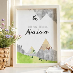 May include: White framed print with a mountain-themed design. The artwork features a climber, mountain silhouettes, and the German text "FÜR DEIN NÄCHSTES Abenteuer" (For your next adventure). Includes a green landscape with trees and the numbers 5 and 50.
