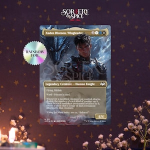 May include: A Magic: The Gathering card featuring "Xaden Riorson, Wingleader." The card has a holographic rainbow foil effect and depicts a human knight with a dragon. The card's text includes "Legendary Creature - Human Knight" and game mechanics.