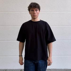 May include: A black oversized t-shirt with short sleeves. The shirt is made of a soft, comfortable fabric.