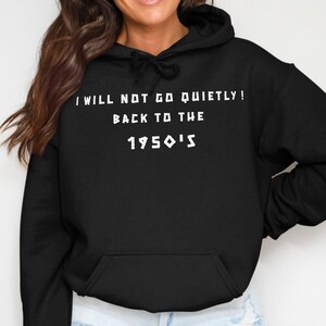 Op de afbeelding: Zwart hoodie met de tekst "I will not go quietly! Back to the 1950's" in wit.