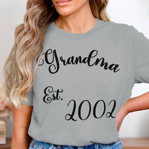 Puede incluir: Camiseta gris con texto negro que dice "Grandma Est. 2002".