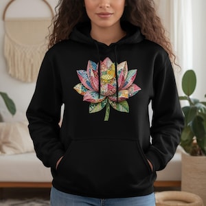 May include: Black hoodie featuring a colorful lotus flower design on the front. The lotus flower is intricately detailed with various colors, including pink, blue, yellow, and green. The hoodie has a drawstring hood and a front pocket.