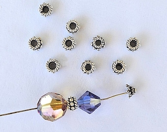May include: Silver spacer beads with a twisted design, a purple crystal bead, and a gold iridescent bead on a wire.