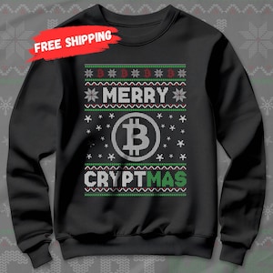 May include: Black sweatshirt with a festive design. The design includes the words "MERRY CRYPTMAS" with a Bitcoin symbol in the center. The design also features snowflakes and green and red accents.