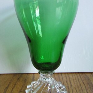 May include: A green glass goblet with a clear glass base. The base has a scalloped design.