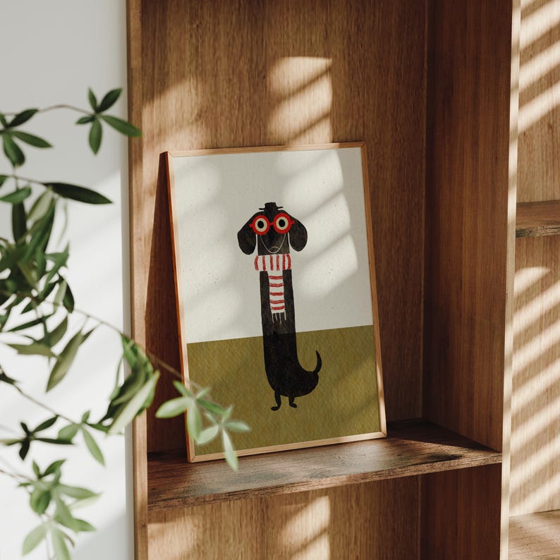 May include: A framed illustration of a black dachshund wearing red glasses and a striped scarf. The dog is standing on a green background.