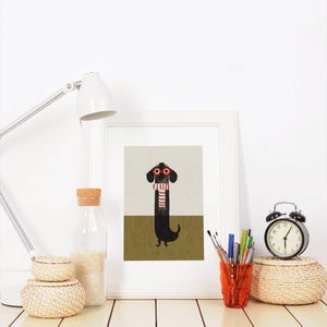 May include: A framed print of a black dachshund wearing red glasses and a red and white striped scarf. The dachshund is standing on a green background.