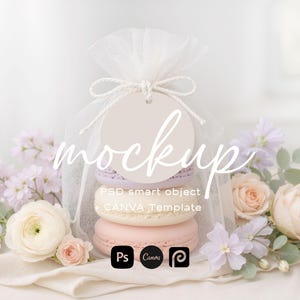 May include: A mockup featuring a stack of pastel macarons inside a sheer white bag tied with a bow and a round tag. The word "mockup" is written across the image. Soft pink and purple flowers surround the bag.