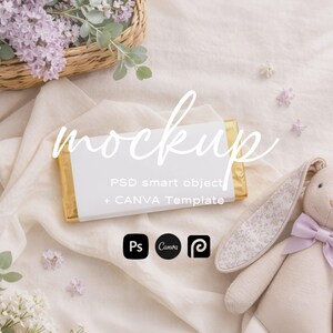 Può includere: Un mockup con una carta bianca e bordi dorati, con la parola "mockup" in corsivo. Un coniglietto di peluche con un fiocco lilla e orecchie con stampa floreale è accanto alla carta. Un cestino di fiori viola e verde è sullo sfondo.