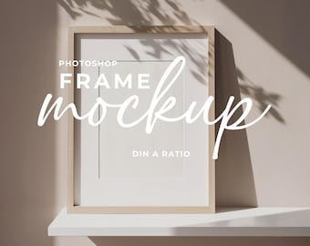 May include: A rectangular wooden frame mockup with a white mount and a white background. The text "Photoshop Frame Mockup" is written in a cursive font. The text "DIN A RATIO" is also visible.