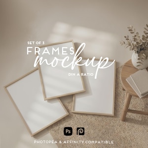 May include: A mockup featuring three rectangular frames with light wood borders, arranged on a textured beige surface. The frames are angled, displaying blank white spaces. Text reads "SET OF 3 FRAMES mockup DIN A RATIO". A small table with a vase and books is in the background.
