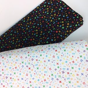 May include: Two rolls of fabric, one black and one white, both patterned with colorful mathematical symbols. The black fabric has symbols in red, green, yellow, and blue. The white fabric has the same symbols in various colors.