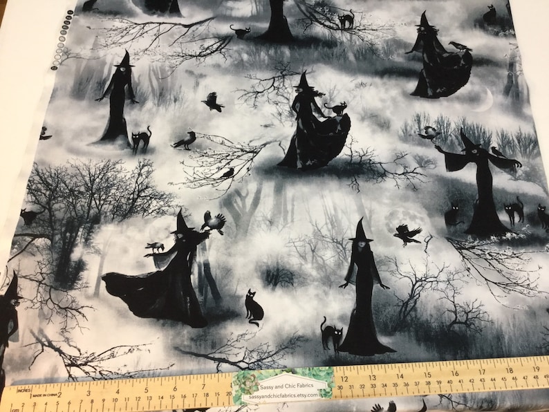May include: Fabric with a spooky Halloween theme. The design features black silhouettes of witches, cats, and crows against a misty, grayscale forest backdrop. The fabric includes the text "Sassy and Chic Fabrics etsy.com".