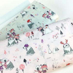 May include: Two rolls of fabric with a winter-themed pattern. One roll is light pink, the other is light green. The pattern features illustrations of children, Old English Sheepdogs, snowmen, trees, and other winter elements.