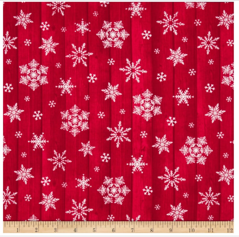 Pu&ograve; includere: Tessuto rosso con un motivo a venature di legno, decorato con fiocchi di neve bianchi di varie dimensioni. I fiocchi di neve presentano motivi dettagliati, creando un tema invernale festivo. Misurazione in centimetri.