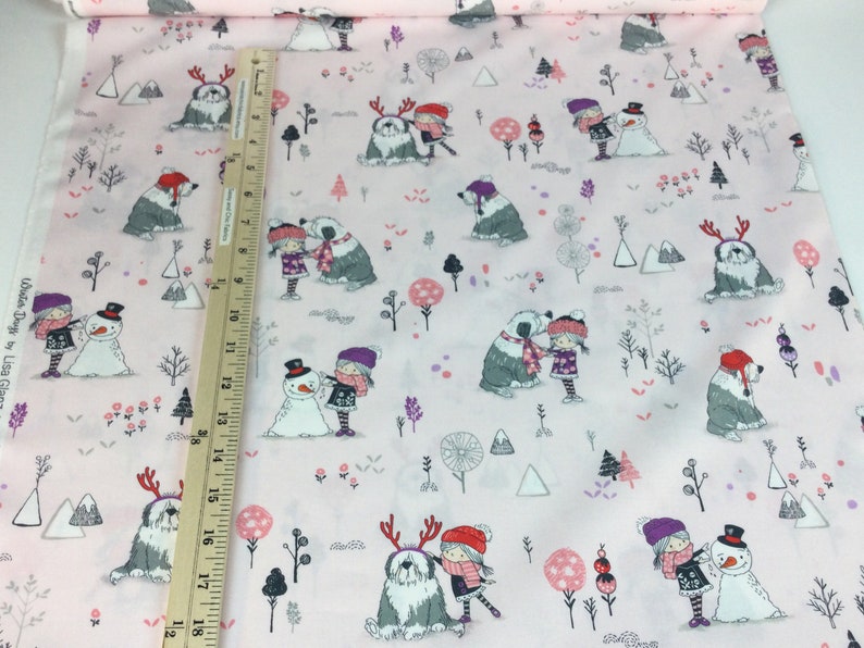 May include: Pink fabric with a winter-themed pattern. The design features illustrations of children, snowmen, dogs, and trees. The fabric is decorated with a ruler for measurement.
