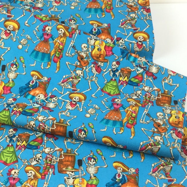 Op de afbeelding: Felblauw textiel met een herhalend patroon van dansende skeletten in feestelijke kleding. De skeletten dragen sombrero's, jurken en bespelen muziekinstrumenten zoals gitaren en maracas. Geschikt voor diverse knutselprojecten.